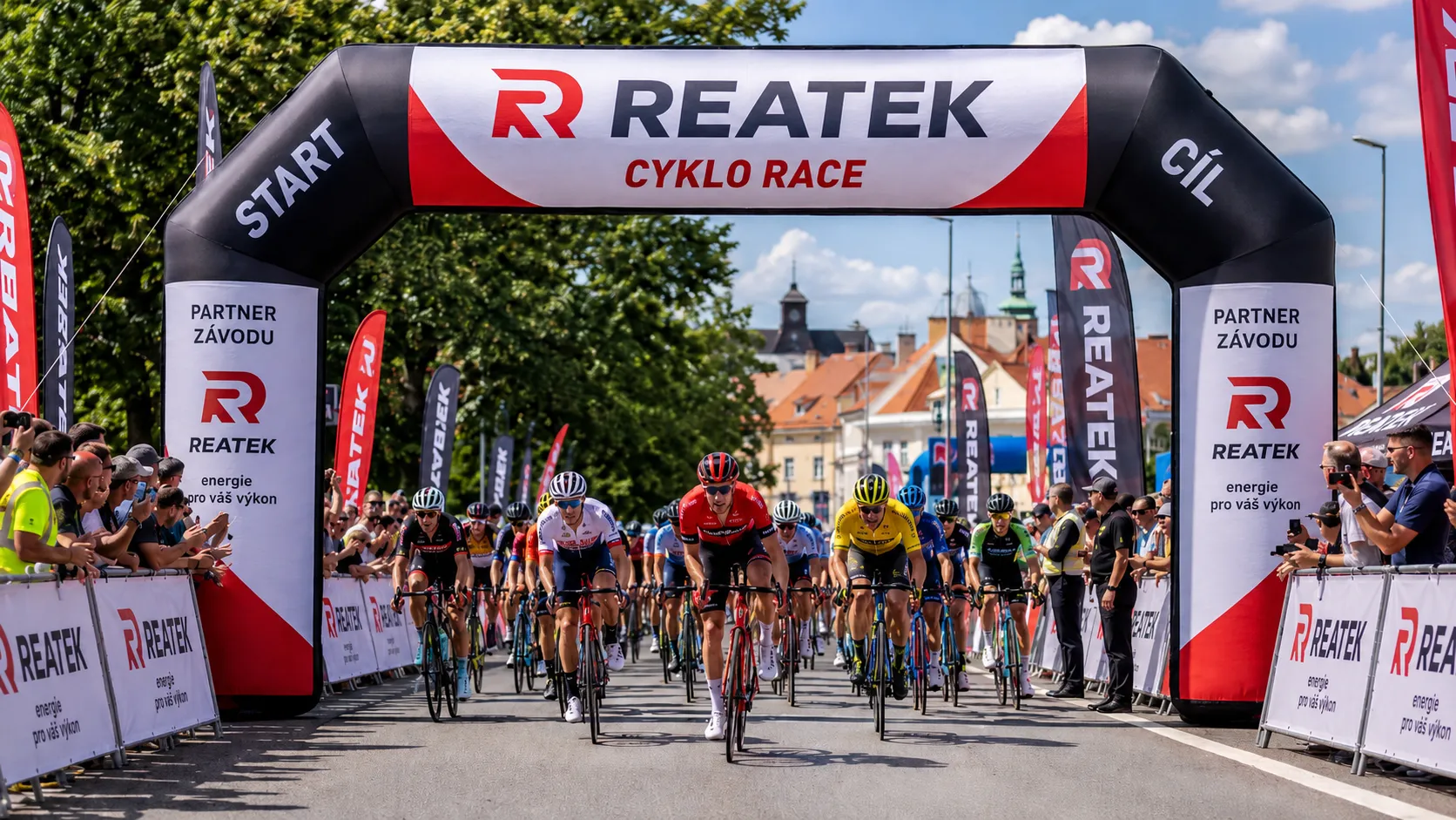 Nafukovací reklamní brána REATEK na cyklistickém závodě se startem, cílem, reklamními bannery a velkým počtem diváků